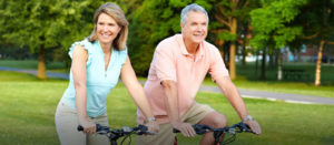 Empty nester senior couple riding bicycles outside